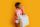 studio-shot-of-pretty-black-woman-with-white-shopping-bag-standing-over-yellow-background-trendy-spring-fashionable-look